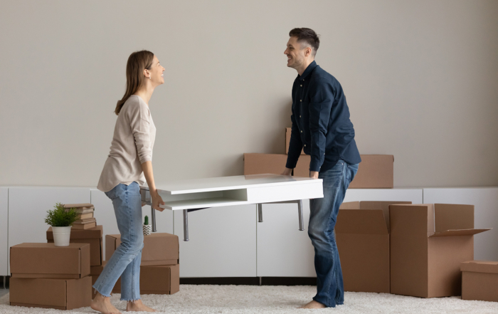 Couple carrying table to living room furnish house with furniture